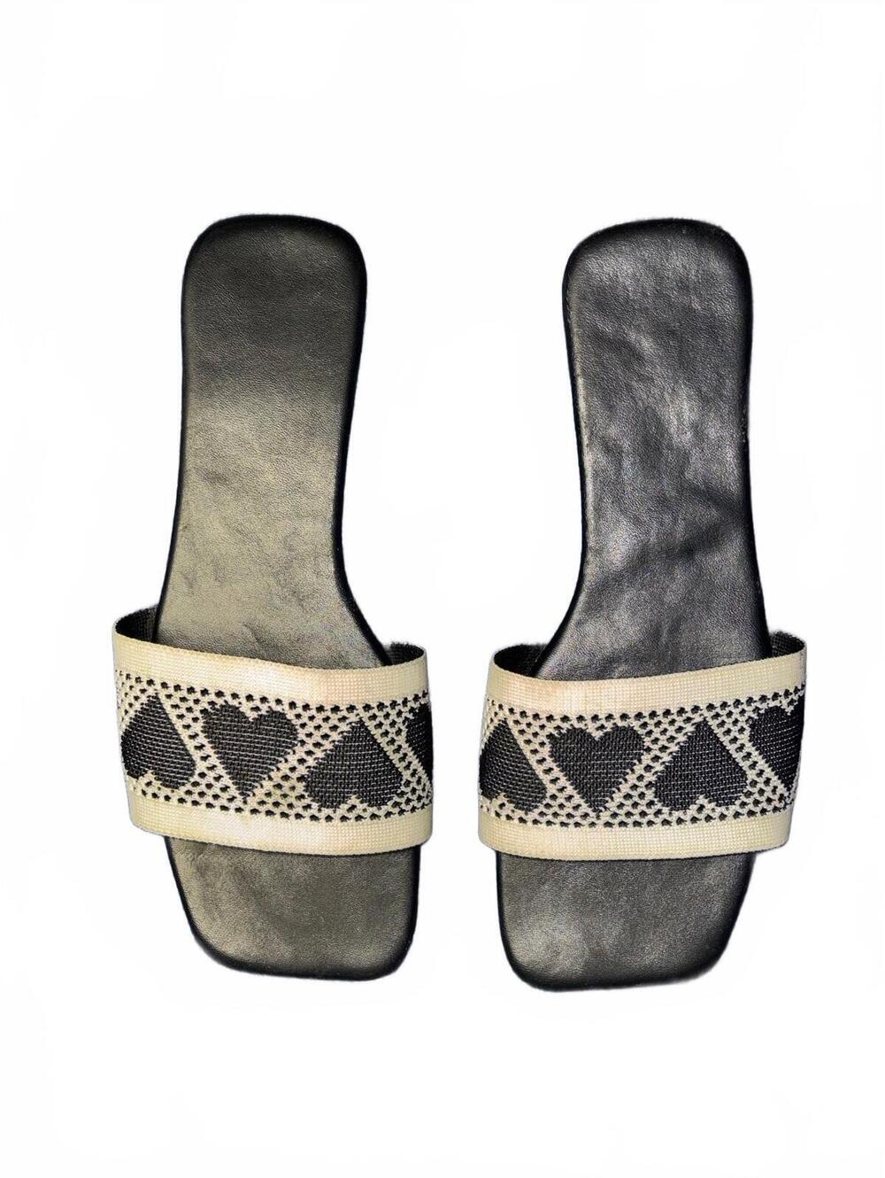 black square-toe slip-on sandals featuring a charming woven heart-print strap